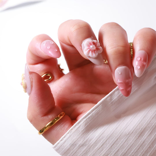 Peach Petals press-on nails worn on hand, soft pink ombre nails with 3D flower and water droplet details