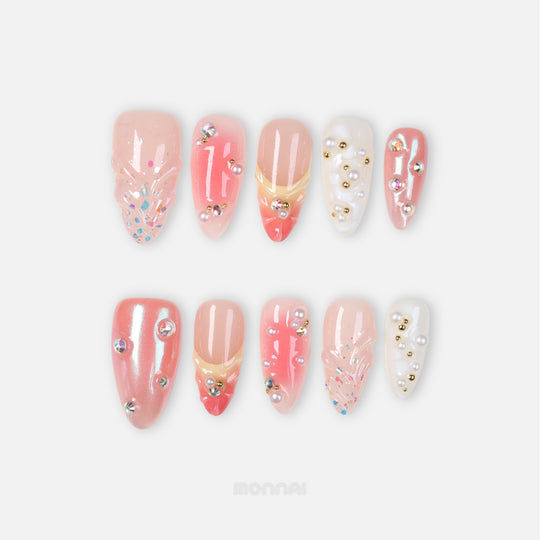Pearl Diaries press-on nails laid out in soft nude pink, coral shimmer, milky white, pearls, and crystal accents
