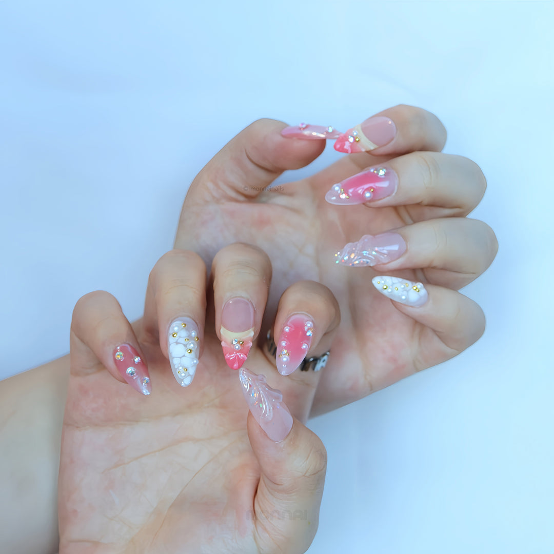 Pearl Diaries press-on nails worn on hands, with sheer nude pink, soft pink shimmer, milky white tips, pearls and crystal accents.