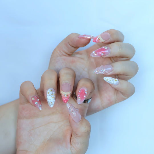 Pearl Diaries press-on nails worn on hands, with sheer nude pink, soft pink shimmer, milky white tips, pearls and crystal accents.