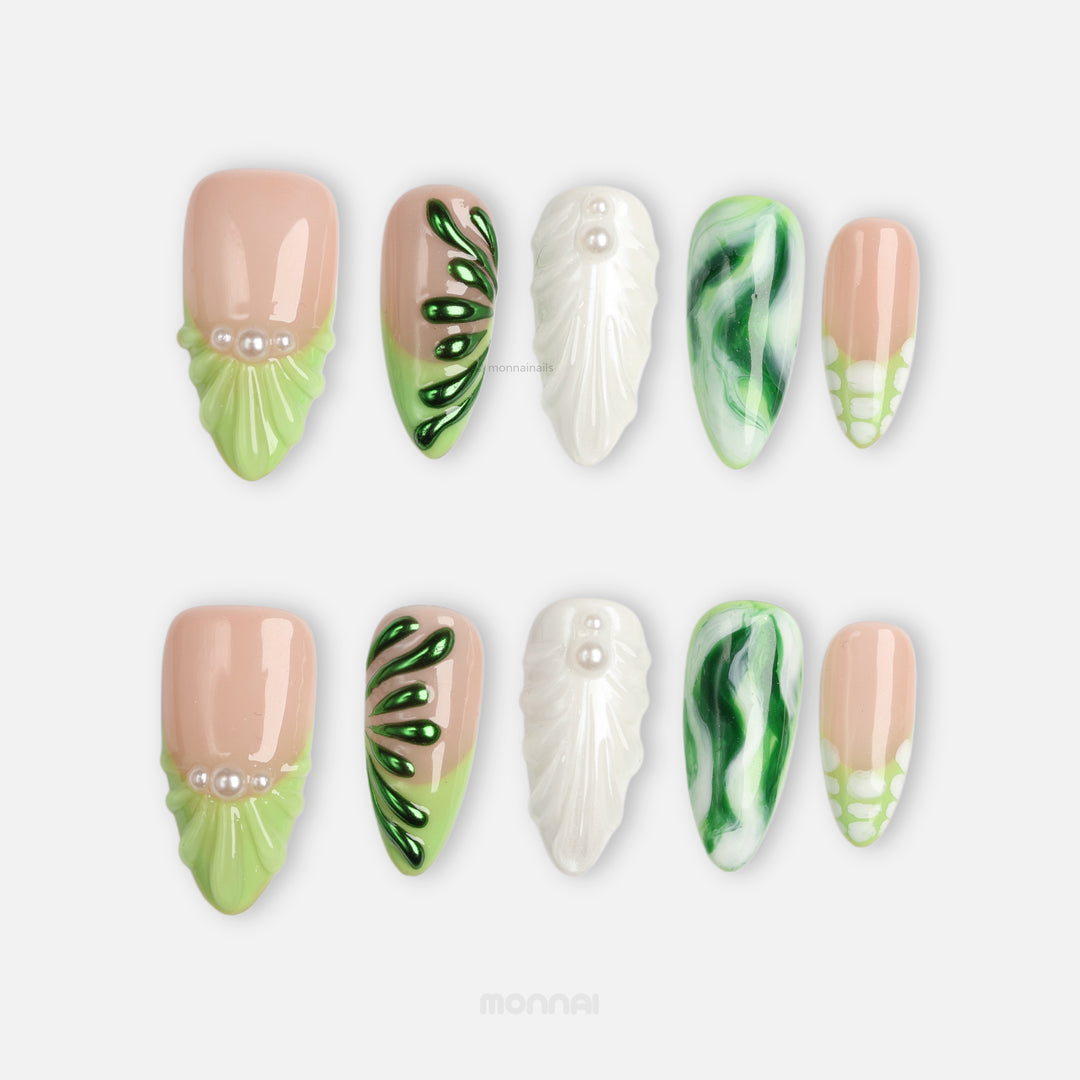 Pearl & Ivy press-on nails laid out in nude, green, pearl, marbled and leaf-textured designs.