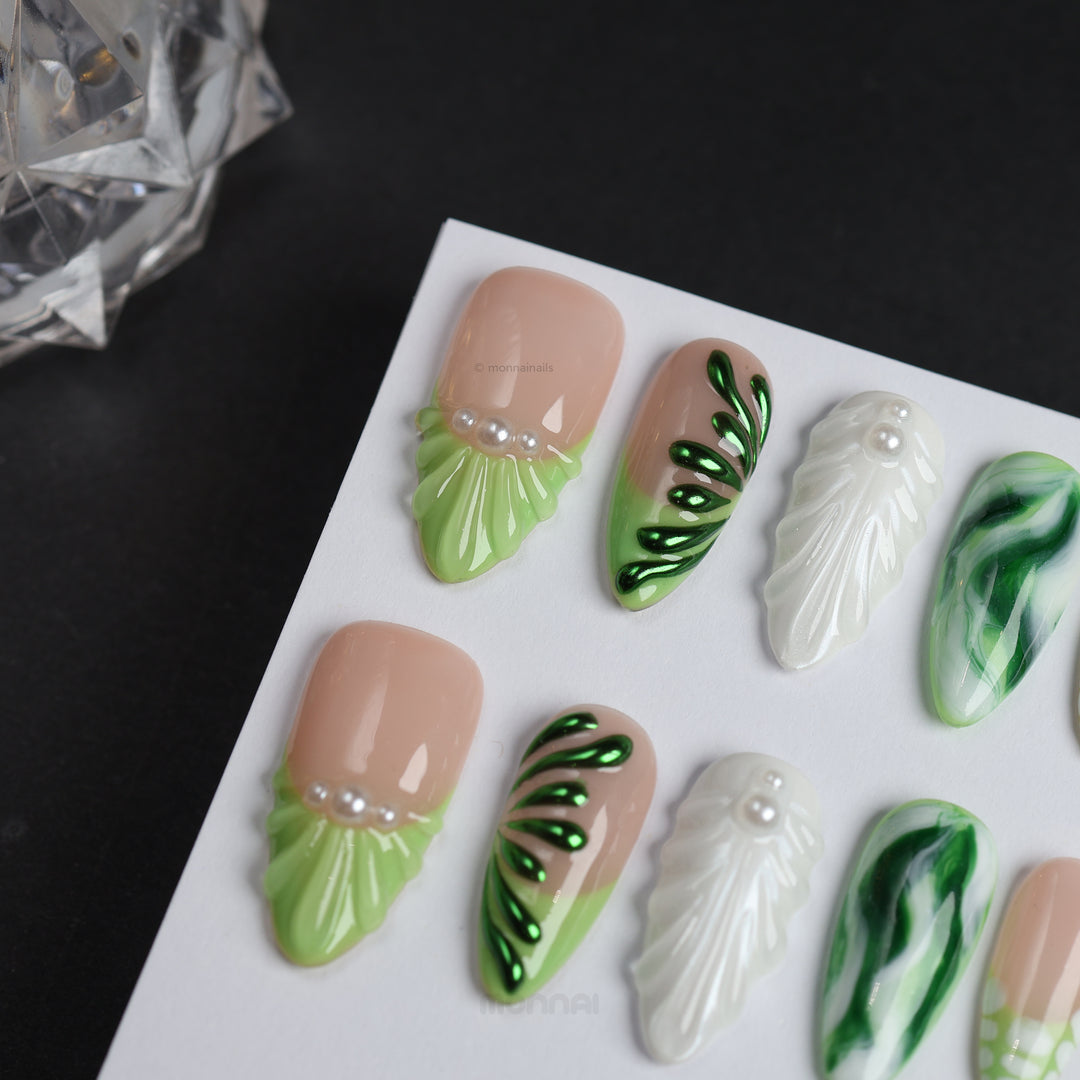 Pearl &amp; Ivy press-on nails shown in close-up, with nude, light green, metallic green, pearl touches, and leaf-like sculpted texture