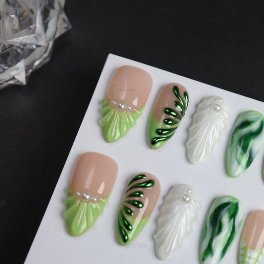 Pearl &amp; Ivy press-on nails shown in close-up, with nude, light green, metallic green, pearl touches, and leaf-like sculpted texture