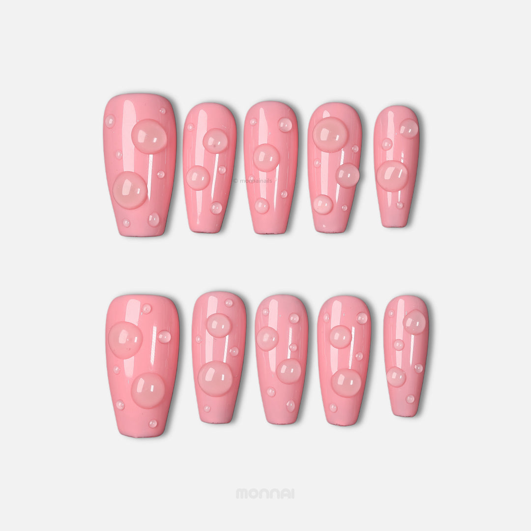 Pink Dew press-on nails in glossy pink with raised dewdrop accents, shown laid out in two rows.