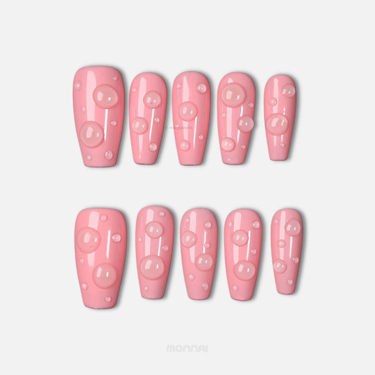 Pink Dew press-on nails in glossy pink with raised dewdrop accents, shown laid out in two rows.