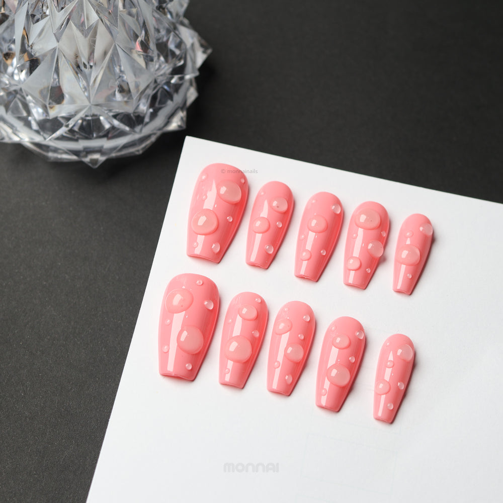 Pink Dew press-on nails with glossy pink finish and 3D dewdrop accents, laid out on a white card.