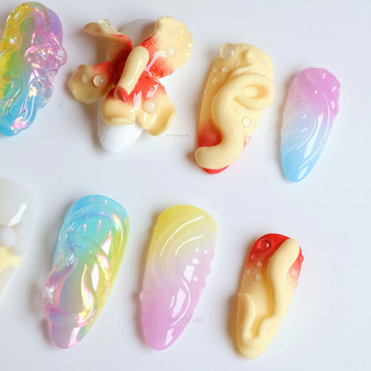 Playful Bloom press-on nails laid out with aurora gradients, frosted textures, and bold 3D floral accents.