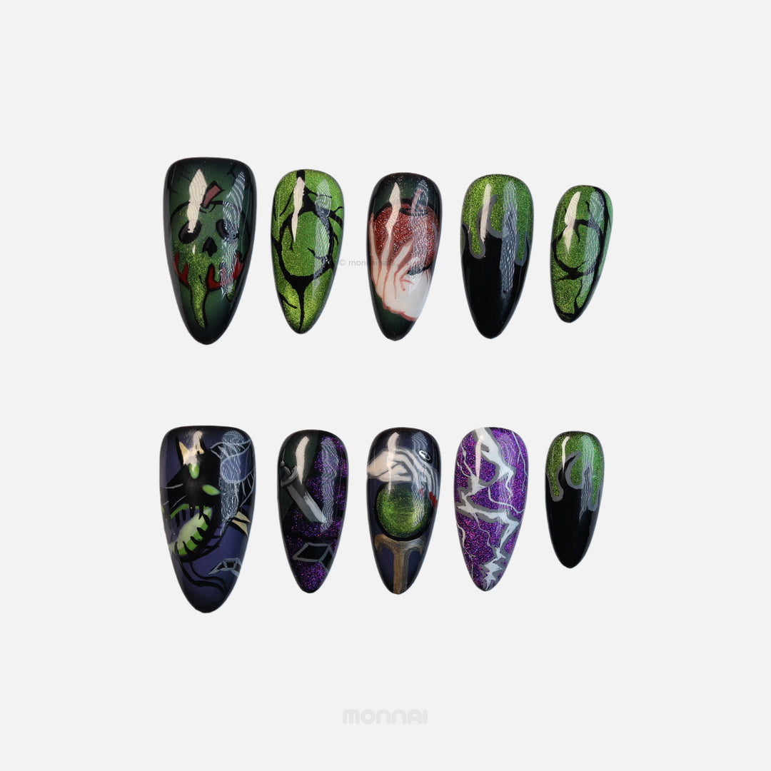 Poison Apple press-on nails laid out, showing dark magic art with green, purple, and black cat eye finishes.