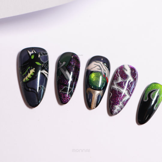 Poison Apple press-on nails laid out, with dark magic art on green and purple cat eye bases and glossy finish.