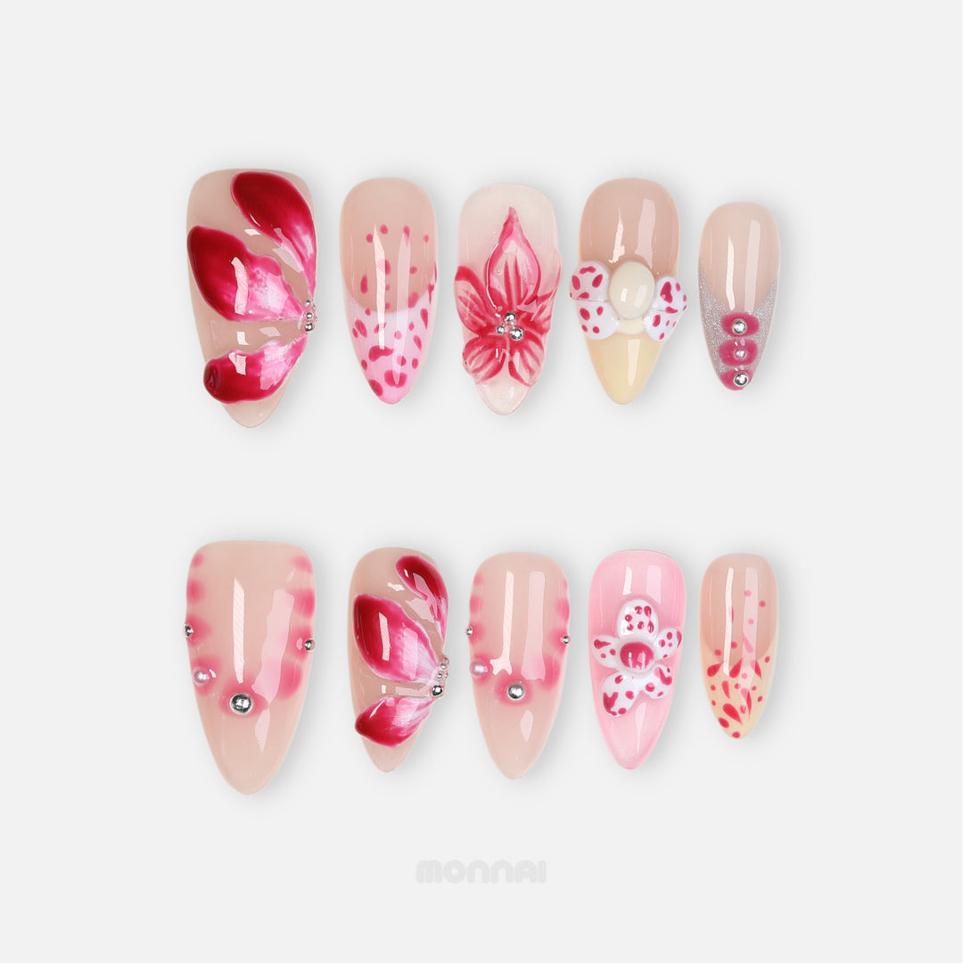 Pretty Petal Party press-on nails laid out with pink floral accents, nude bases, rhinestones, and glossy petal details.