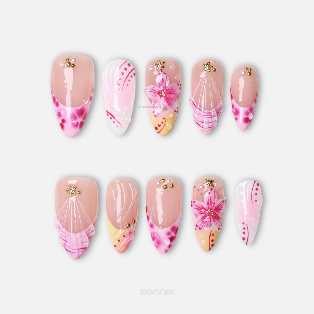 Pretty in Pink press-on nails laid out in close-up, pink floral accents, gold stars, and glossy jelly nude tones.