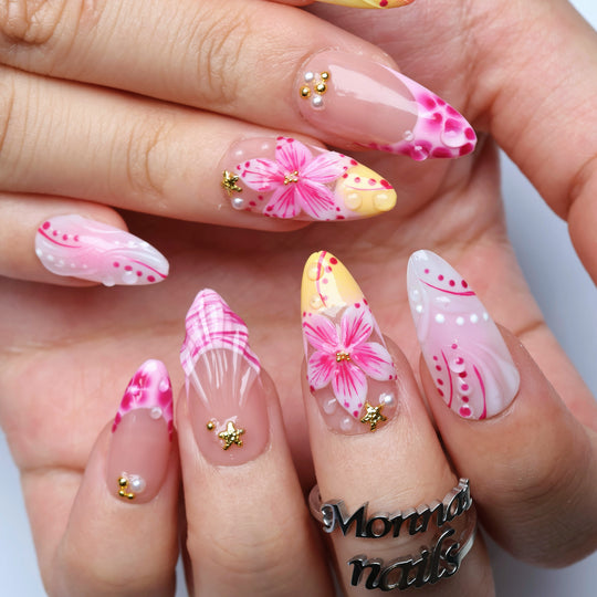 Pretty in Pink press-on nails worn on hands, featuring pink floral art, yellow accents, and gold star details
