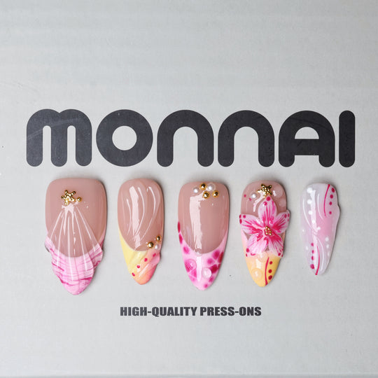 Pretty in Pink press-on nails laid out with jelly nude base, pink florals, gold star accents, and glossy iridescent details