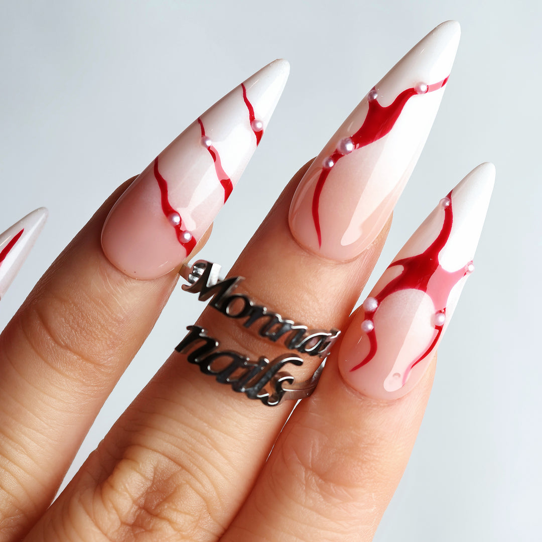 R-ED press-on nails worn on hand, dark romance design with red fluid lines and pearls.