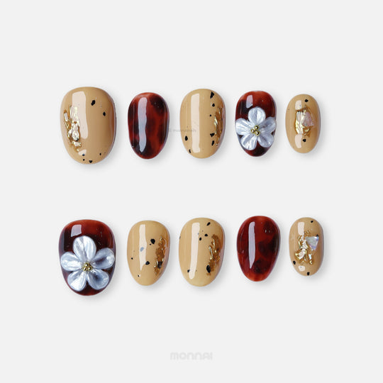 Radiance press-on nails with beige and tortoiseshell floral designs, gold foil, and glossy nude accents