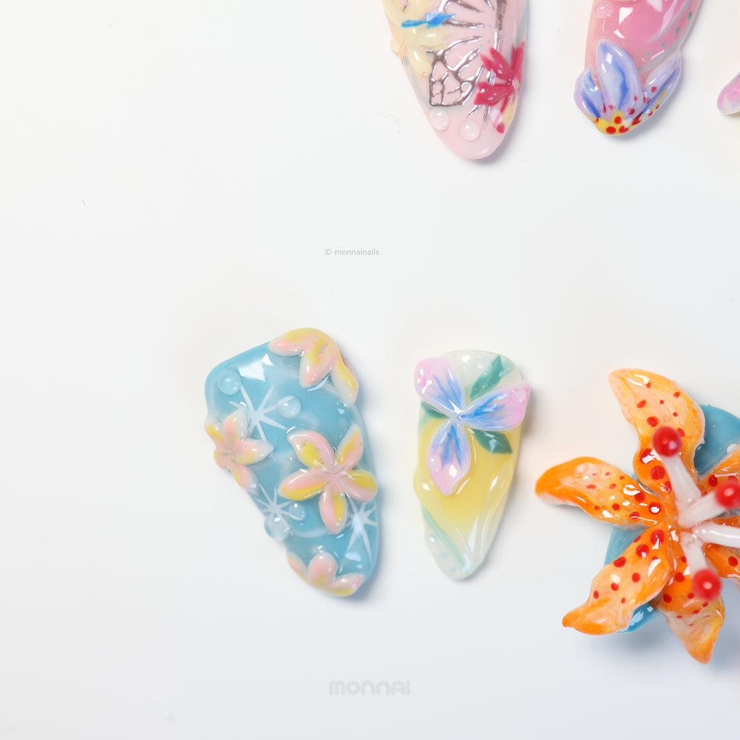 Radiant Bloom press-on nails laid out in close-up, with soft pastel 3D flowers, translucent layers, and glossy details