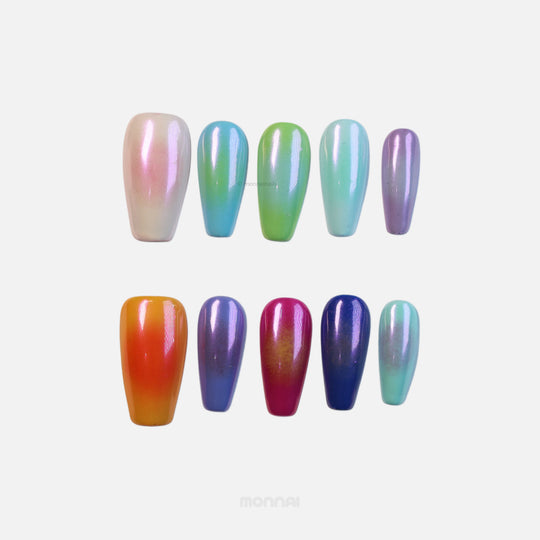 Rainbow Glow press-on nails shown laid out in a chromatic, iridescent mix of pastel and vivid shades with soft aura effects.