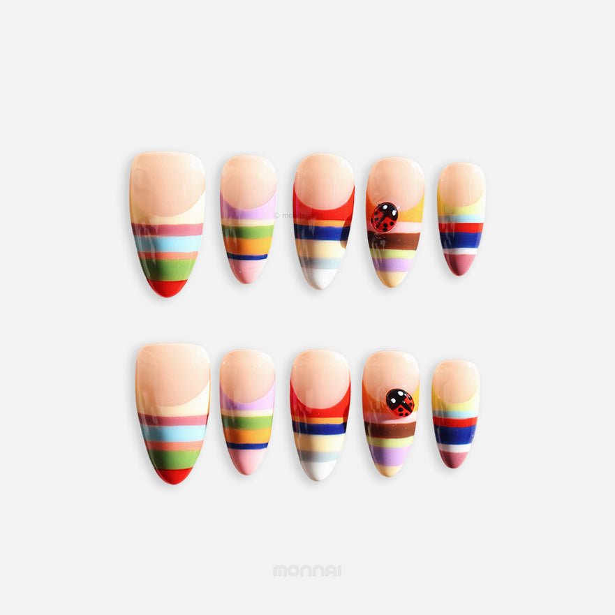Rainbow Stripes press-on nails, full set with nude base, colorful horizontal stripes and ladybug accent, playful