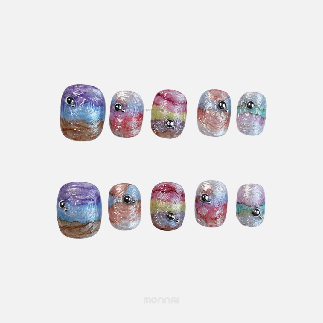 Rainbow Swirl press-on nails shown in close-up, with iridescent wavy texture and silver bead accents