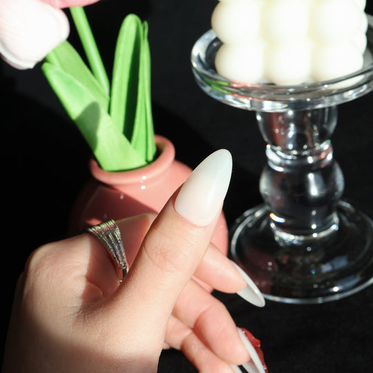 Red Leaves press-on nails shown worn on hand, with milky white nails and sheer red leaf detailing.