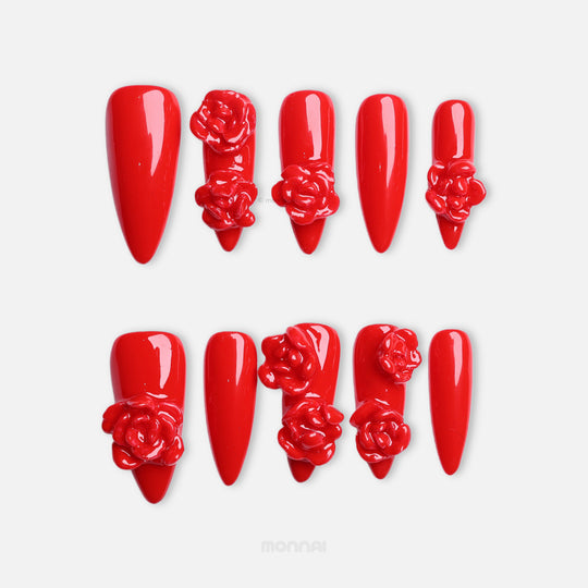 Red Rose press-on nails in glossy red, shown laid out with bold 3D rose details on several nails.