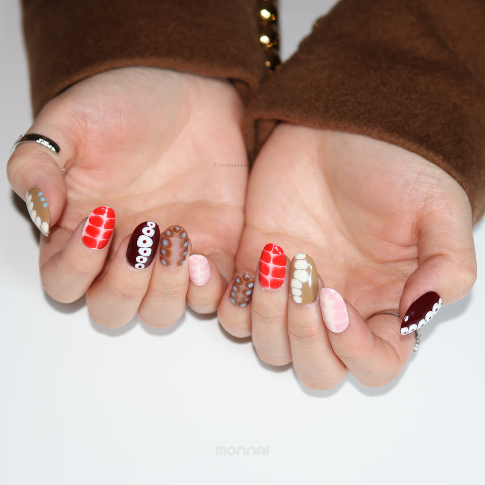 Retro Groove press-on nails worn on hands, with retro color-blocking, abstract animal print textures, and glossy red, brown, and pink shades.