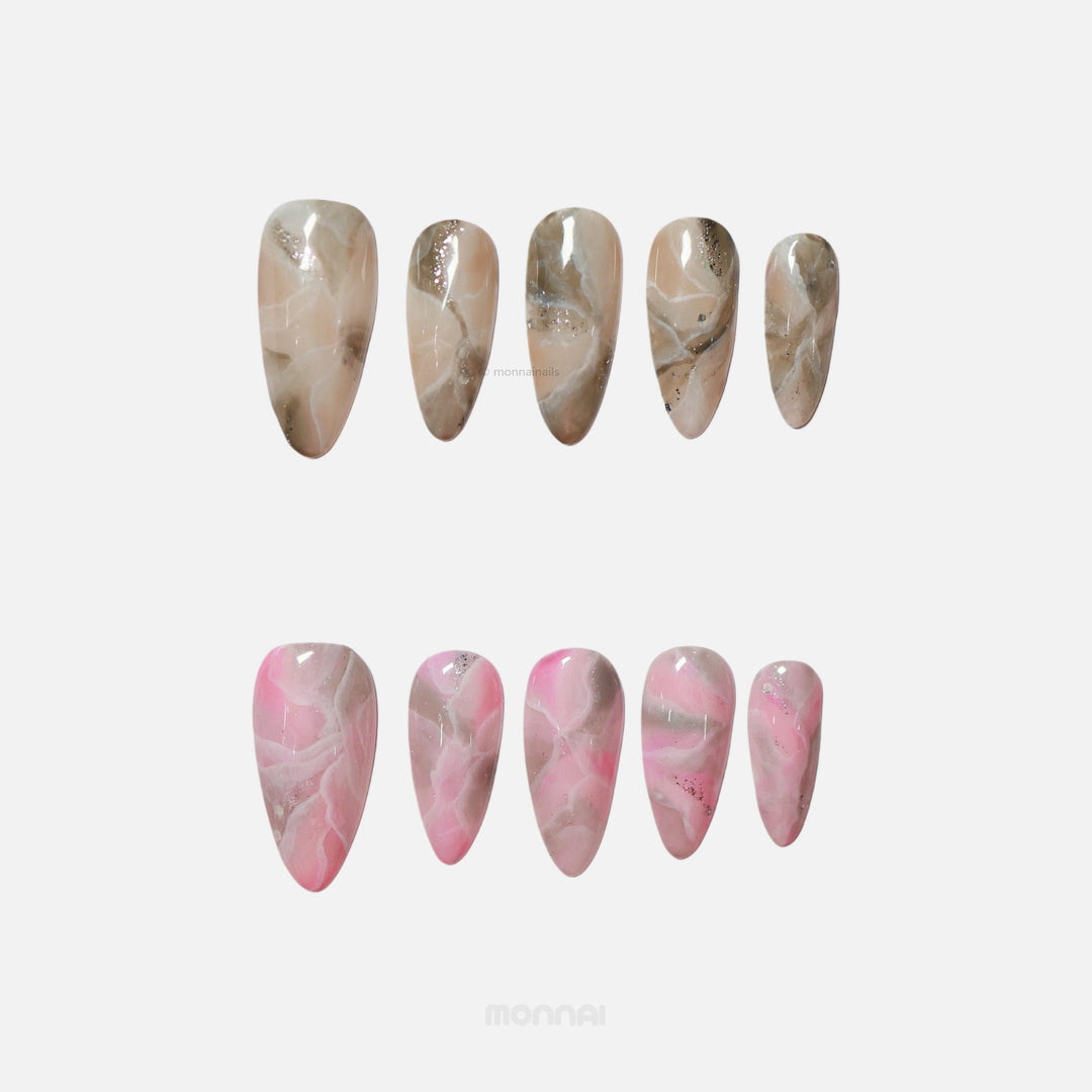 Rose Marble press-on nails laid out in smoky marble beige and pink with subtle silver glitter accents.