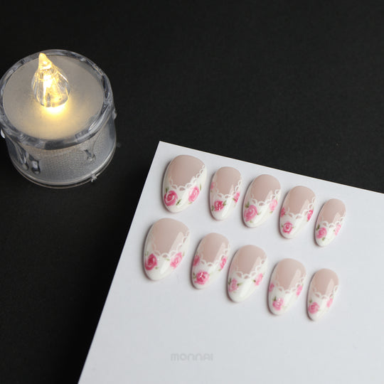 Rosy Lace press-on nails laid out with nude, white lace edging and pink rose floral details