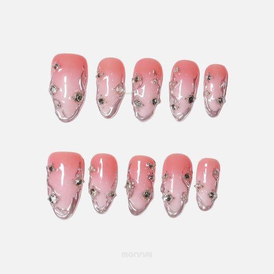 Rosy Metallic Touch press-on nails with pink shimmer gradient, fluid 3D borders, and clear rhinestones laid out in two rows.