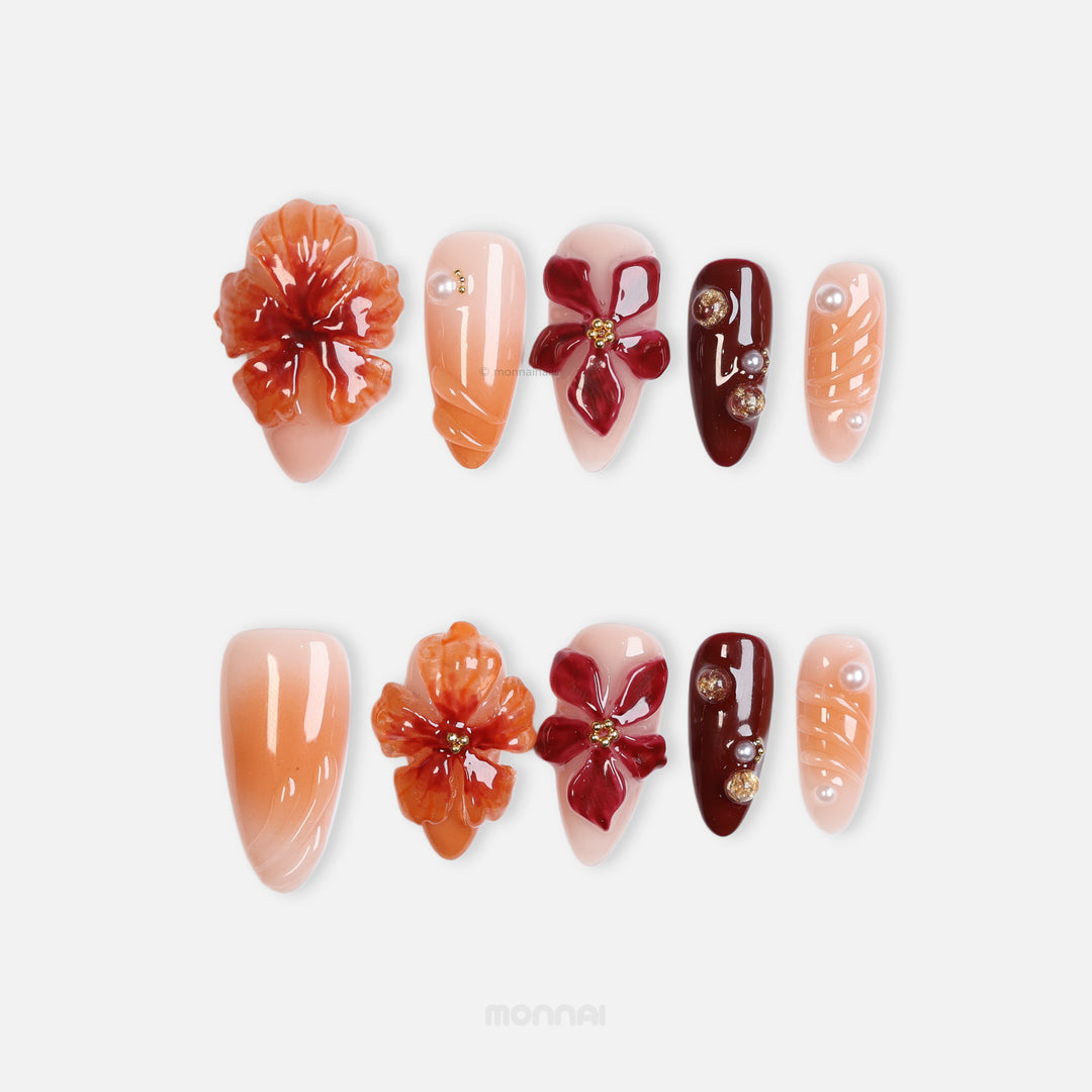 Rustic Elegance press-on nails laid out in close-up, with coral and deep berry 3D flowers, soft gradients, and gold accents