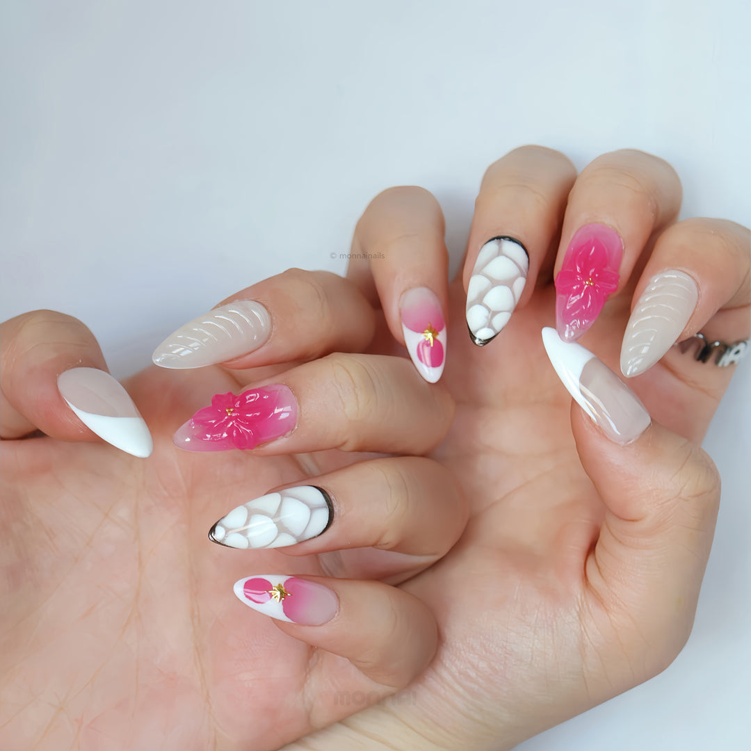 Sakura Kiss press-on nails worn on hands with nude, milky white and hot pink 3D flower details