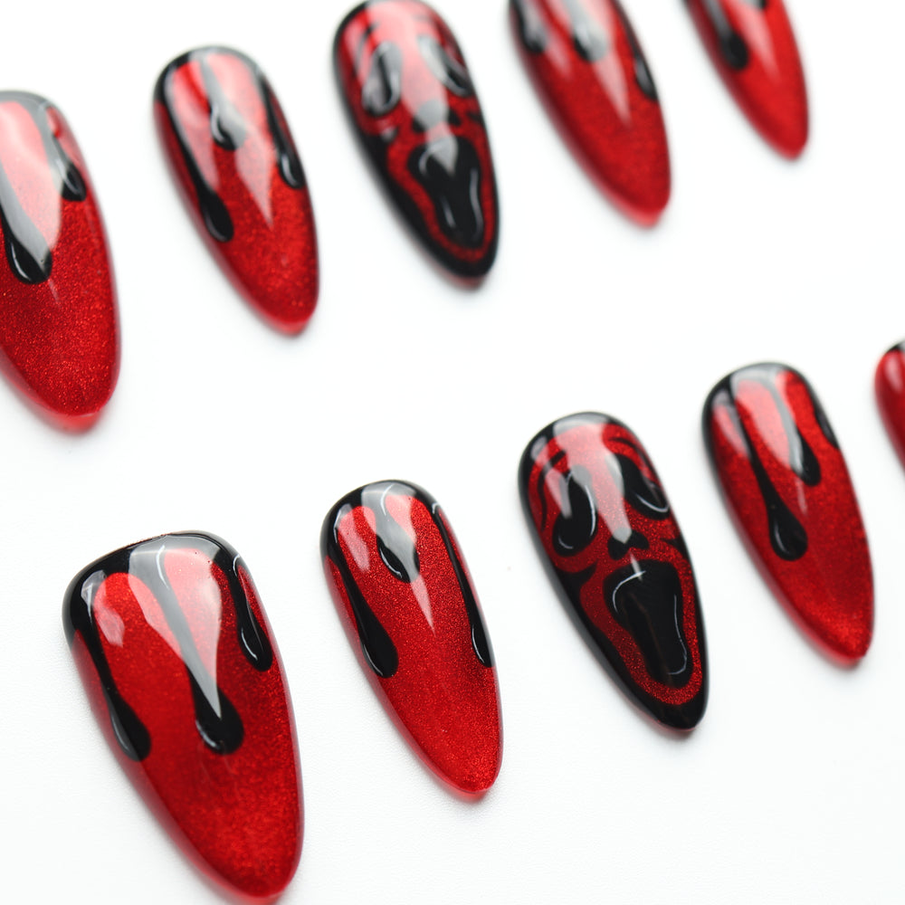 Scarlet Scream press on nails with shimmering crimson, glossy black drips, and screaming faces for Halloween