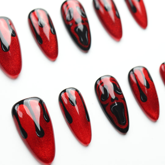Scarlet Scream press on nails with shimmering crimson, glossy black drips, and screaming faces for Halloween