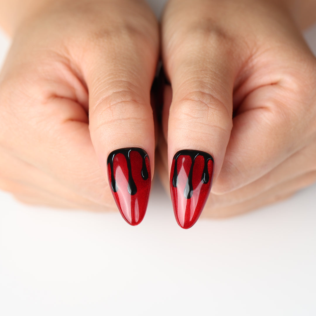 Scarlet Scream press on nails with crimson shimmer and glossy black drips for a bold Halloween look