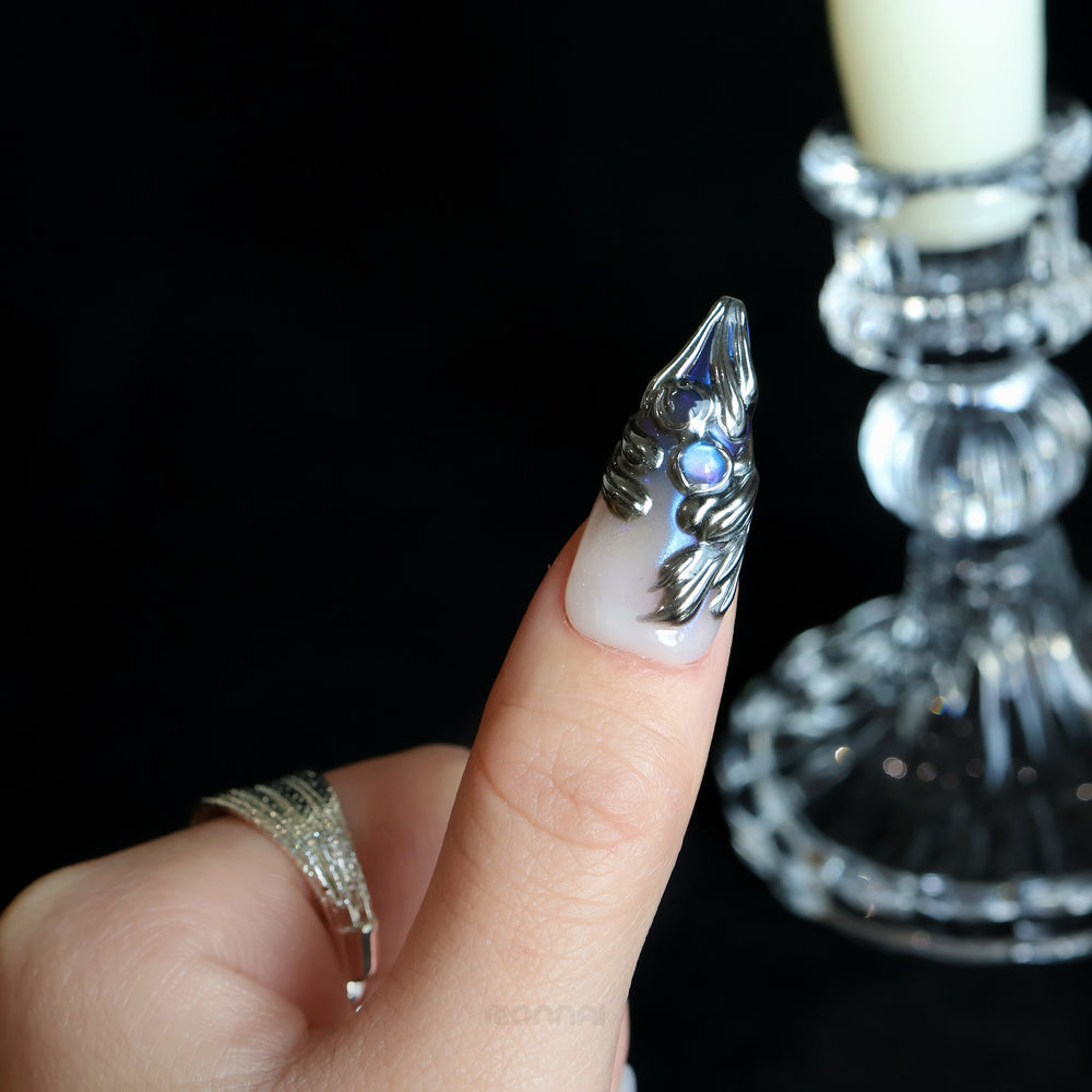 Silver Dreams press-on nails on hand, chrome feather design with icy white base and iridescent accents