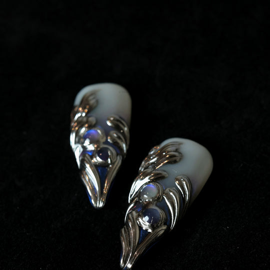 Silver Dreams press-on nails with icy white base, chrome feather-like textures, and subtle iridescent blue accents.