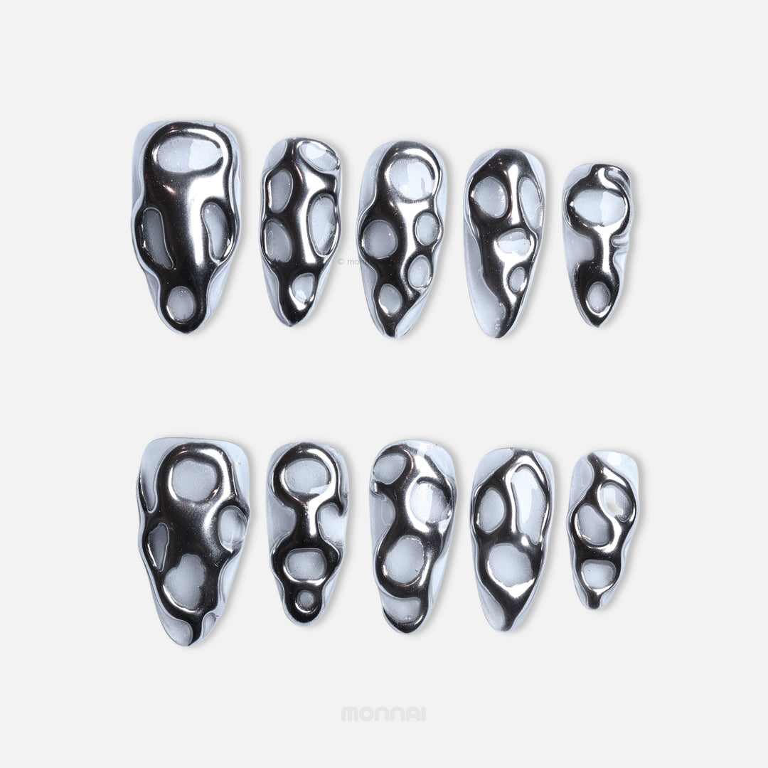 Silver Flow press-on nails in close-up, featuring sleek liquid silver chrome openwork on clear bases