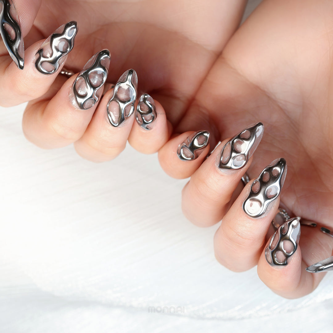 Silver Flow press-on nails on hand, liquid-metal silver chrome openwork design with sculptural, sleek finish