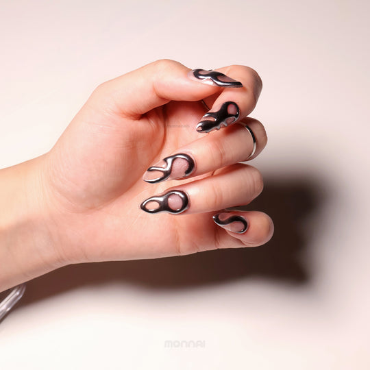Silver Mystic Flow press-on nails with liquid chrome sculptural silver waves shown on a hand