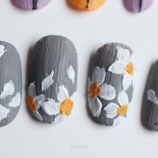Spring on Canvas press-on nails with grey textured canvas finish and white floral details, laid out in close-up