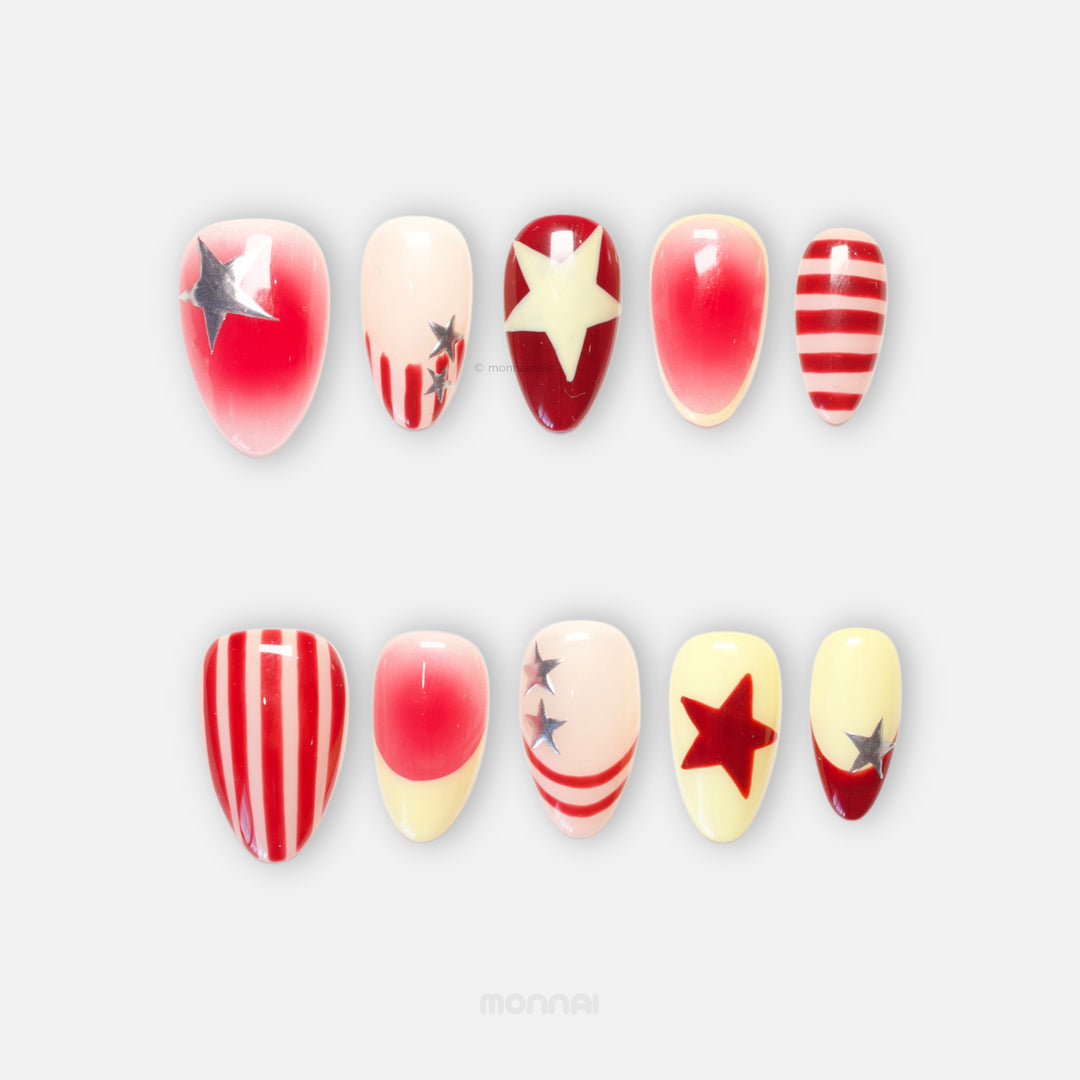 Star Parade press-on nails with red and butter yellow star designs, hand-painted stripes, and silver accents laid out in two rows.