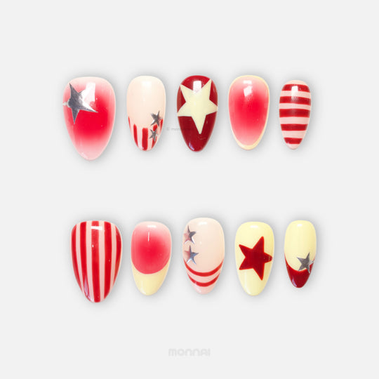 Star Parade press-on nails with red and butter yellow star designs, hand-painted stripes, and silver accents laid out in two rows.