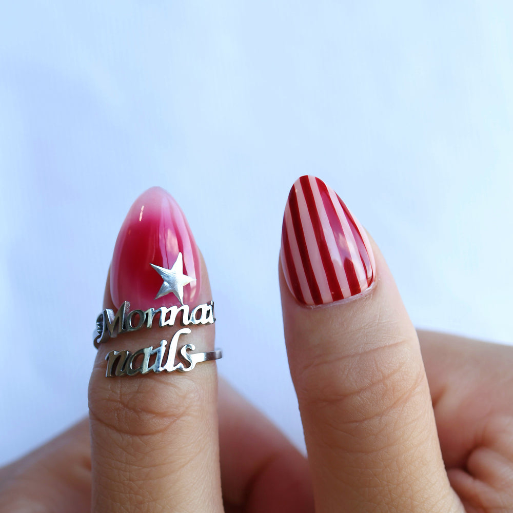 Star Parade press-on nails worn on hands, red aura gradient with butter yellow stripes and silver star detail.