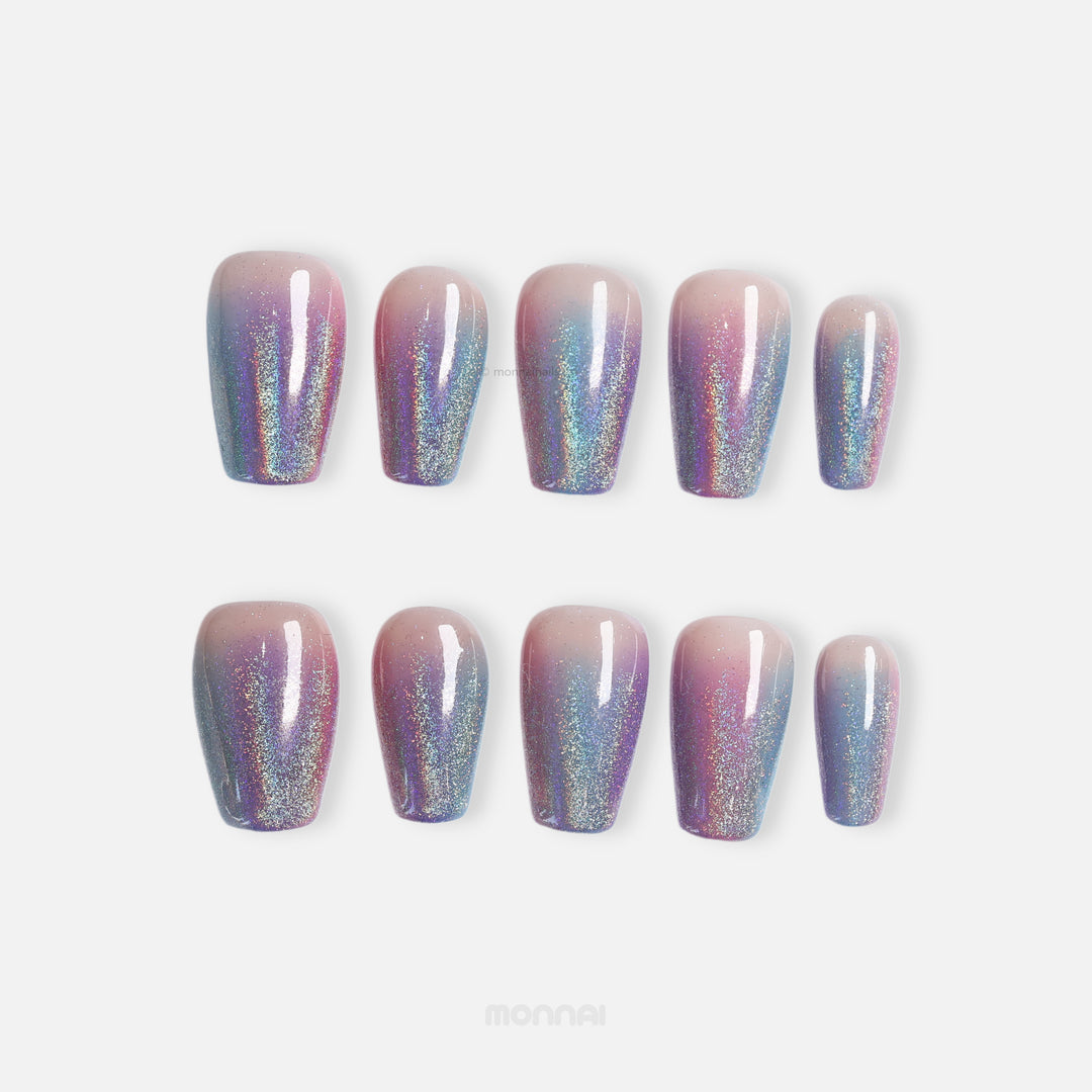 Stardust press-on nails with nude, pink, and blue glitter ombré shown in a laid-out set.