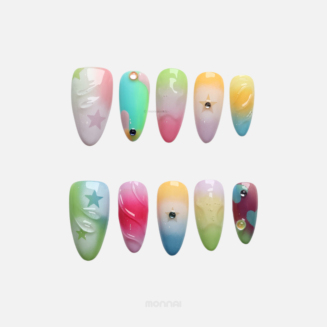 Starlight Pastels press-on nails with soft pastel fades, glossy raised details and tiny star accents, shown laid out.