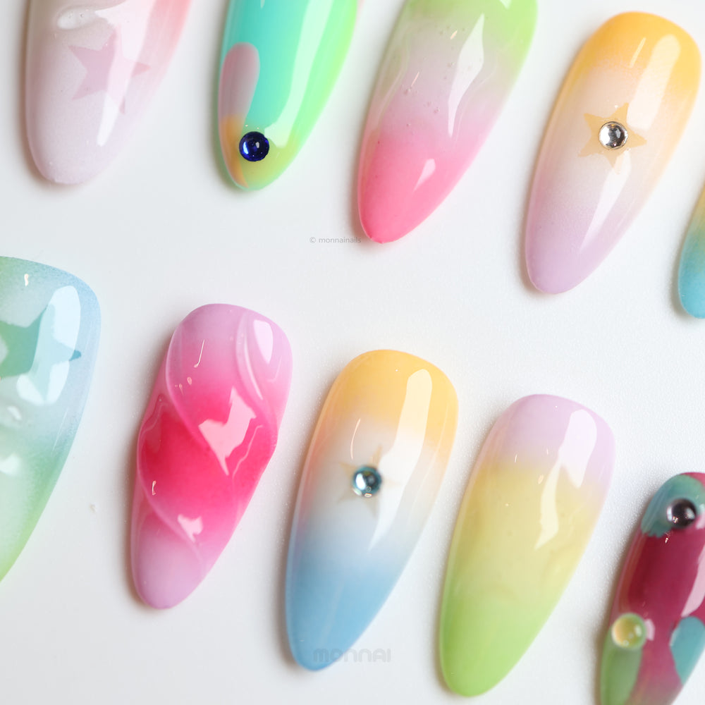 Starlight Pastels press-on nails laid out in close-up with glossy pastel fades, tiny stars, and bead-like accents