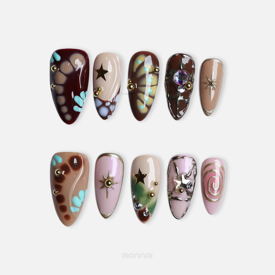 Starlit Glow press-on nails laid out in retro mix with crocodile-print, stars, crystals, and nude brown tones