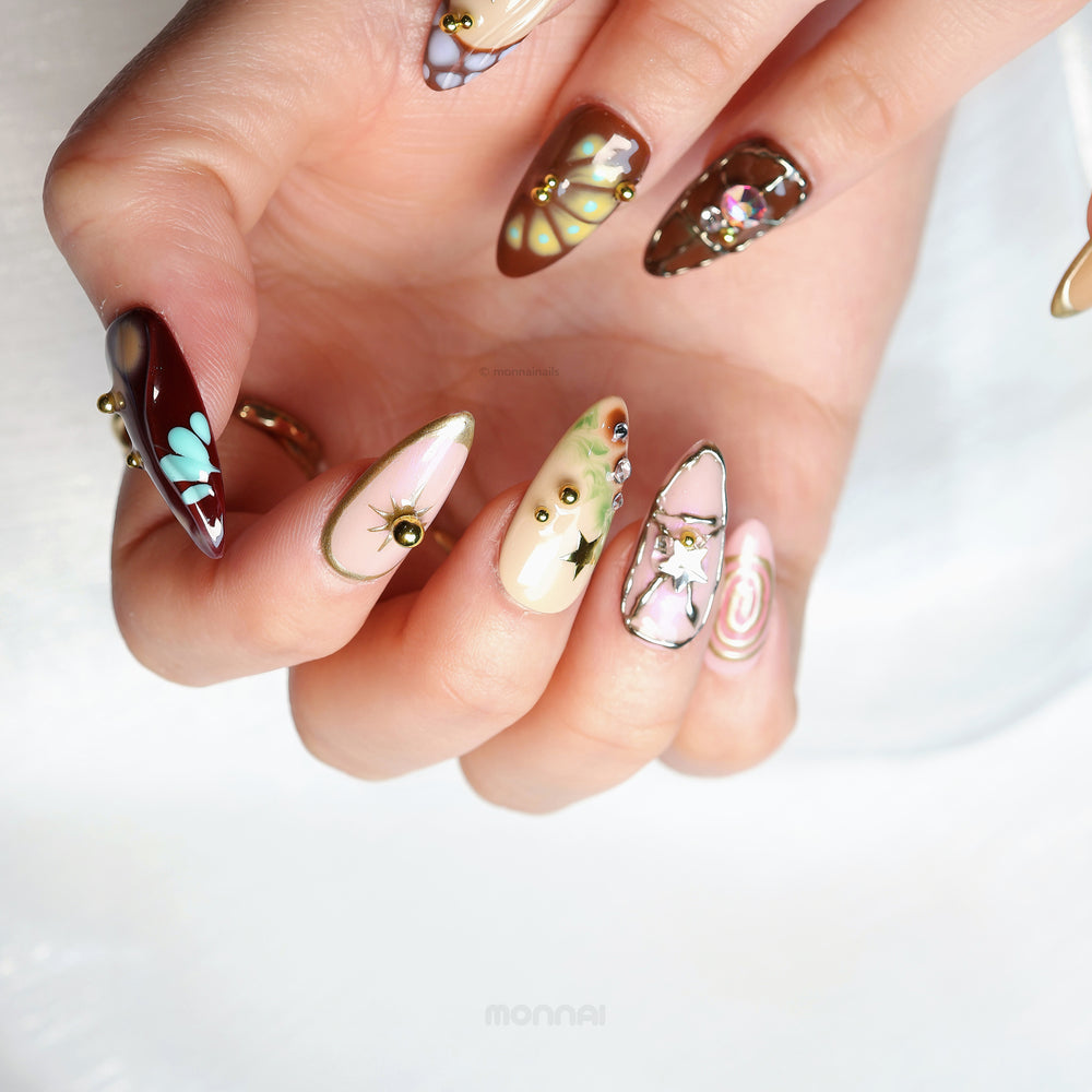 Starlit Glow press-on nails worn on hand, retro playful nude and brown nails with star motifs and crystal accents.