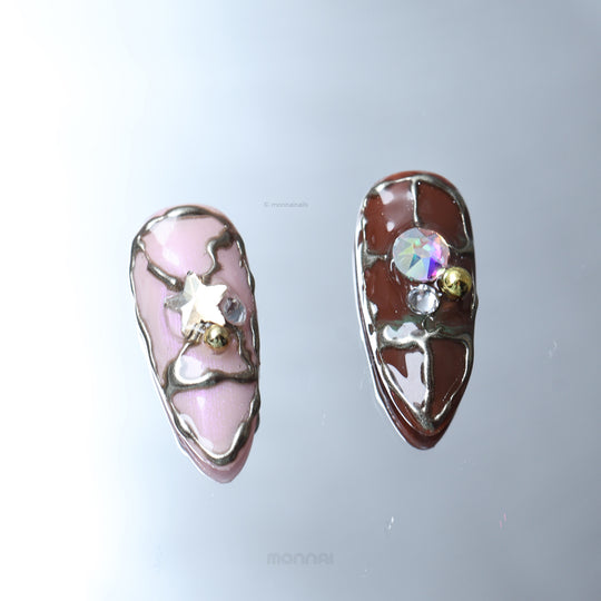 Starlit Glow press-on nails laid out in close-up, with retro playful pink and brown tones, metallic accents, and star crystal details.