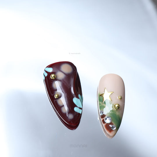Starlit Glow press-on nails in close-up, with retro playful nude, brown and burgundy designs, star and crystal accents